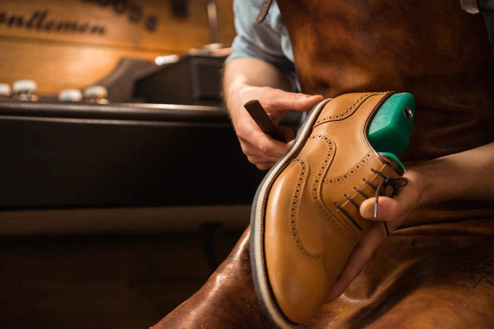 schuhmacher-in-der-werkstatt-schuhe-machen_171337-12277